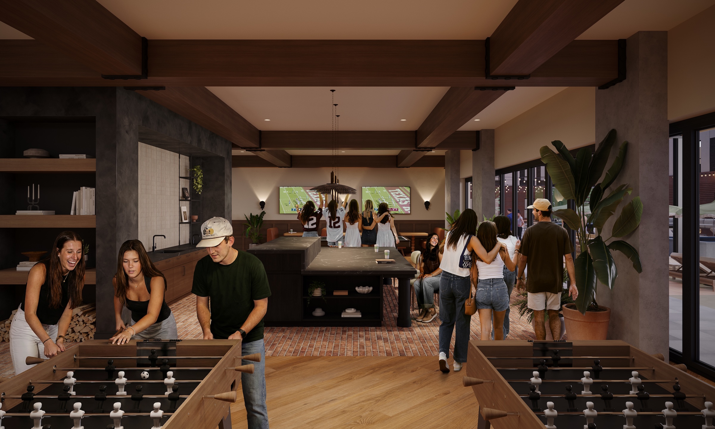 Texas A&M students playing foosball and watching the Aggies game in the clubroom of The Jay student housing.